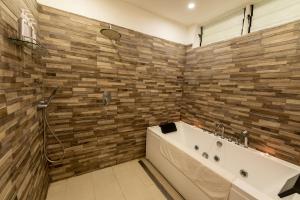 a bathroom with a tub and a shower at Diamonds Malindi in Malindi