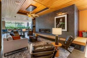 a living room with leather furniture and a fireplace at Cambria Hotel Austin Airport in Austin