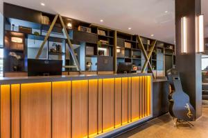 a bar with a guitar in a room at Cambria Hotel Austin Airport in Austin