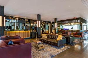 a lobby with leather couches and a bar at Cambria Hotel Austin Airport in Austin