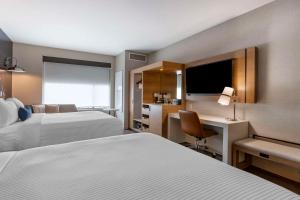 a hotel room with two beds and a desk at Cambria Hotel Austin Airport in Austin