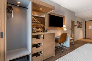 a bedroom with a bed and a desk in a room at Cambria Hotel Austin Airport in Austin