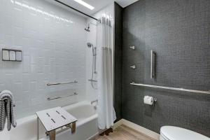 a bathroom with a tub and a toilet and a sink at Cambria Hotel Austin Airport in Austin
