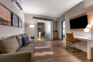 a living room with a couch and a desk at Cambria Hotel Austin Airport in Austin