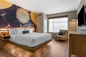 a bedroom with a large bed and a chair at Cambria Hotel Austin Airport in Austin