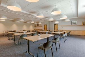 an empty classroom with tables and chairs and lights at Cambria Hotel Austin Airport in Austin +37 photos
