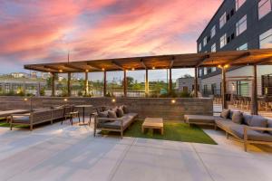 a rooftop patio with couches and tables on a building at Cambria Hotel Austin Airport in Austin