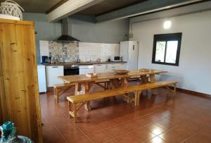 a large kitchen with a wooden table and benches at Casa Rural Granja Abril in Cardiel de los Montes