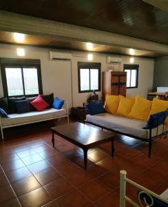 a living room with two couches and a coffee table at Casa Rural Granja Abril in Cardiel de los Montes +6 photos
