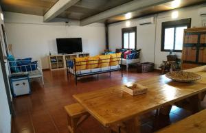 a living room with a wooden table and chairs at Casa Rural Granja Abril in Cardiel de los Montes