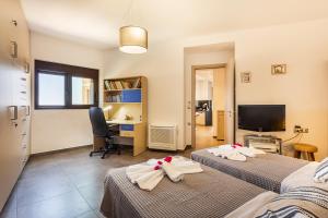 a bedroom with two beds and a desk with a computer at VenMar luxury house in Plataniás