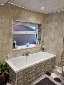 a large bath tub in a bathroom with a window at Studio Near Beach Garden Parking PetsOK in Sunderland
