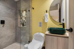 a bathroom with a shower and a toilet and a sink at Casa Origo Hospedaje in Medellín