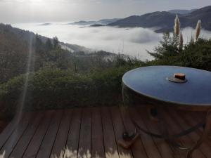 a table on a deck with a view of the mountains at La hautcsur la colline in Yzeron