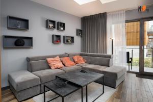 ein Wohnzimmer mit Sofa und Tisch in der Unterkunft Apartamenty Premium STONE HILL - Baseny&Jacuzzi in Szklarska Poręba