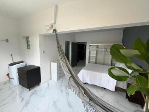 a hammock in a bedroom with a bed at Adriana Beach in Ilha Comprida +23 photos