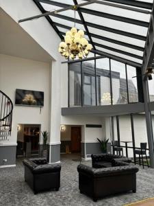 a living room with couches and a chandelier at Britannia Hotel Wigan in Standish
