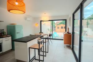 - une cuisine avec un comptoir et quelques tabourets dans l'établissement La contemporaine 2 chambres à Ste Marie, à Sainte-Marie-la-Mer 17 autres photos