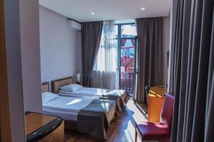 una camera d'albergo con due letti e una finestra di Irmeni Hotel a Tbilisi City