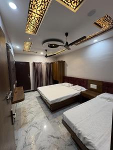 乌贾因shree trilokeshwar guest house的酒店客房设有两张床和天花板
