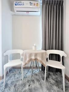 two white chairs and a table in a room at AVALYN Room Plus III - East Ville in Ban Hua Khao Sammuk +9 photos