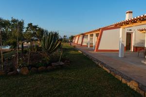 a house with a garden next to a building at Choeiro Verde - Casa de Campo na Costa Vicentina in Brejao
