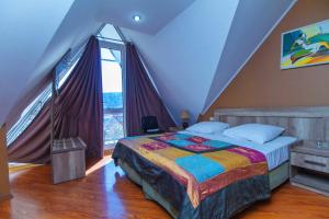una camera da letto con un letto e una grande finestra di Irmeni Hotel a Tbilisi City