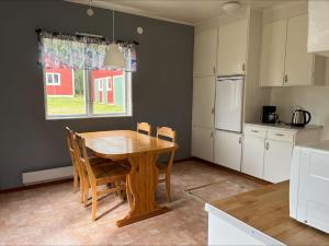 a kitchen with a wooden table and chairs in a room at Stuga, lantligt lugnt läge med gott om parkering in Gällivare