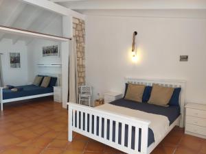 a bedroom with a white bed and a mirror at Vista Mar - Seafront Holiday Apartments in Santa Maria