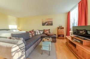 a living room with a couch and a bed at Seeadler - Gemütliches Apartment mit Balkon & Panoramablick auf die Müritz in Waren