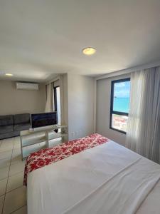 a bedroom with a large bed and a window at Flats Vista Mar PontaNegra in Natal