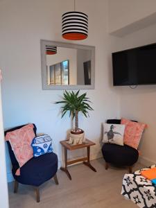 a living room with two chairs and a tv at The Fuzzy Duck in Broughty Ferry