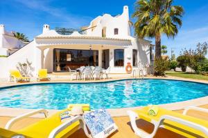 a villa with a swimming pool in front of a house at Villa Veiguinha in Galé