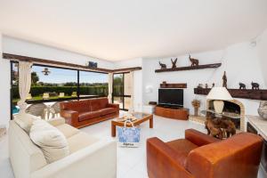 a living room with leather furniture and a fireplace at Villa Veiguinha in Galé