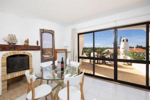 a living room with a fireplace and a glass table and chairs at Villa Veiguinha in Galé