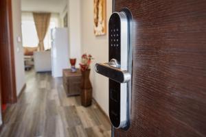 einem Schließen einer Holztür mit einem Griff in der Unterkunft Apartamente Aparthotel Ella Boutik Cytadell in Eforie Sud
