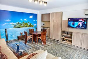 ein Wohnzimmer mit einem Esstisch und einem TV in der Unterkunft Apartamente Aparthotel Ella Boutik Cytadell in Eforie Sud + 89 Fotos
