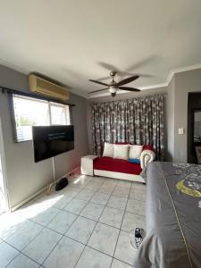 een woonkamer met een bank en een flatscreen-tv bij Zoe & Saint in Kaapstad