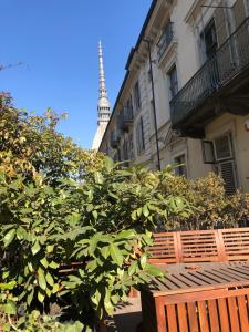 una panca di legno di fronte a un edificio con la torre Eiffel di Camera con terrazzo sotto la Mole a Torino