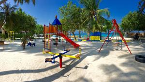 un parque infantil con un tobogán en la arena en Faza View Inn, Maafushi en Maafushi