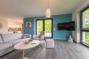 a living room with a couch and a table at Shanti-Suite mit Dachterrasse, Kamin & Sauna am Krakower See in Krakow am See