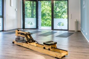 an empty gym with a pilates machine in a room with windows at Bewusstsein - Modernes Apartment mit Terrasse, Walk-In-Dusche & Wellnesszugang in Krakow am See +17 photos
