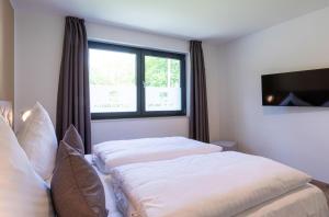 a bedroom with two beds and a window at Glücksraum - Modernes Apartment mit Panoramablick, Kamin & Wohlfühlambiente in Krakow am See