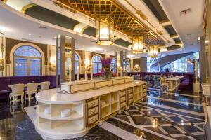 a lobby of a hotel with a counter and chairs at d'Primahotel Bandung in Bandung