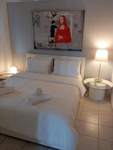 a bedroom with a large white bed with a towel on it at Three Goods Trikala Meteora in Tríkala