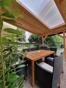 a wooden table and chairs under a pergola at Ferienwohnung mit Fitnessstudio Top2 in Plauen