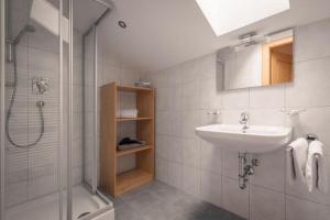 ein Badezimmer mit Waschbecken und Dusche in der Unterkunft Apartments SARLO in Sankt Anton am Arlberg