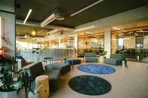 a large lobby with couches and tables and plants at Micampus Braga Student Residence in Braga