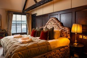 a bedroom with a large bed with a wooden headboard at Salisbury Arms Hotel in Hertford
