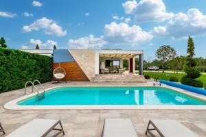 a swimming pool with a patio and a house at Villa Royal Green One in Nin